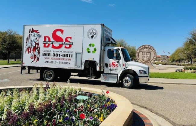 A DSS mobile shredding truck is shown in front of the monument sign for Texas Tech University in Lubbock, TX .