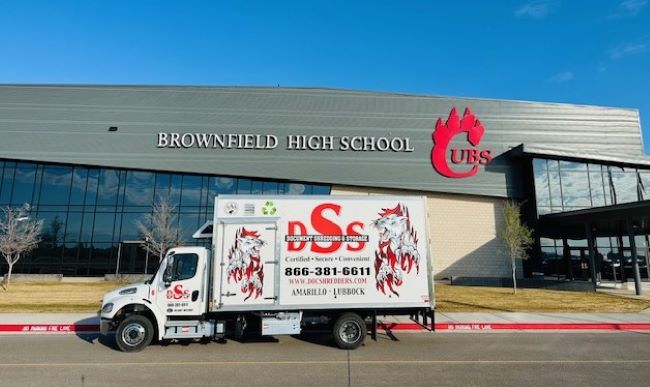 A DSS mobile shredding truck is parked in front of Brownfield High School.