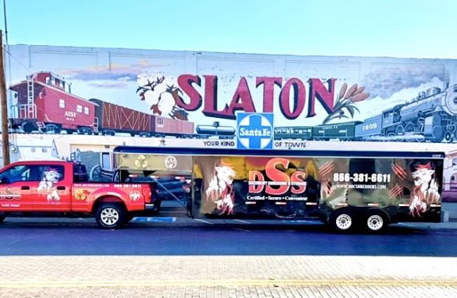 A DSS truck and trailer is parked in front of a large wall mural in Slaton ,TX.