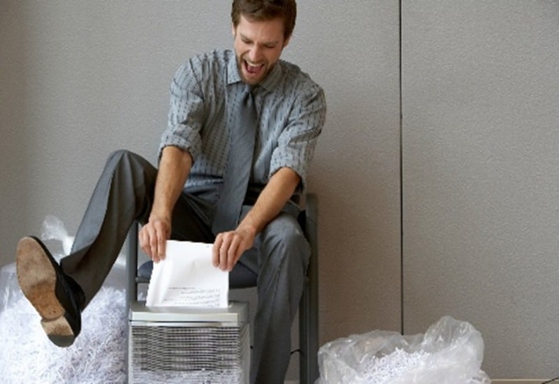 Office employee shredding documents