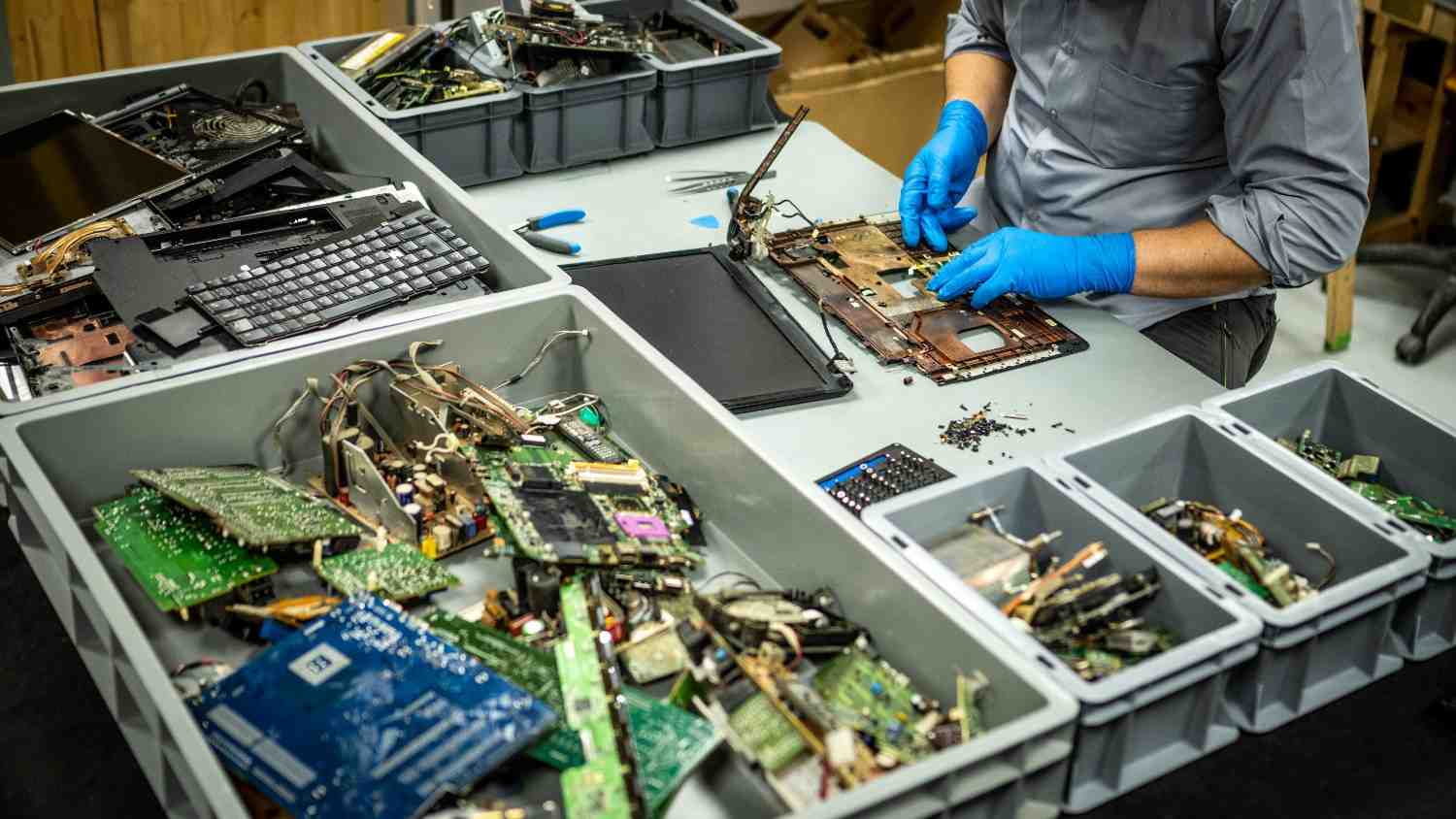 Computer Disposal Services in Lubbock, TX, with a staff member working on laptops and electronic waste components.