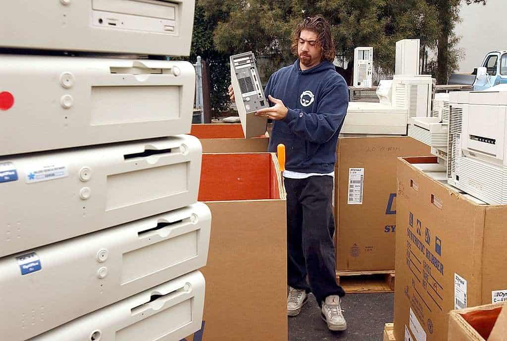 Worker sorting old computers for secure disposal & recycling in Lubbock, TX, facility to protect data & prevent e-waste risks